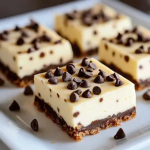 Delicious cheesecake bars topped with chocolate chips on a wooden table.