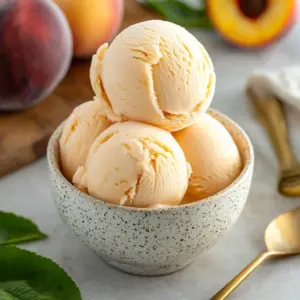 Creamy homemade peach ice cream with fresh peach slices on top